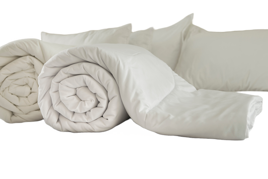 A set of white Down Dreams Asheville Down Comforters and pillows on a white background made with Manchester Mills Cotton Barrier Weave Fabric.